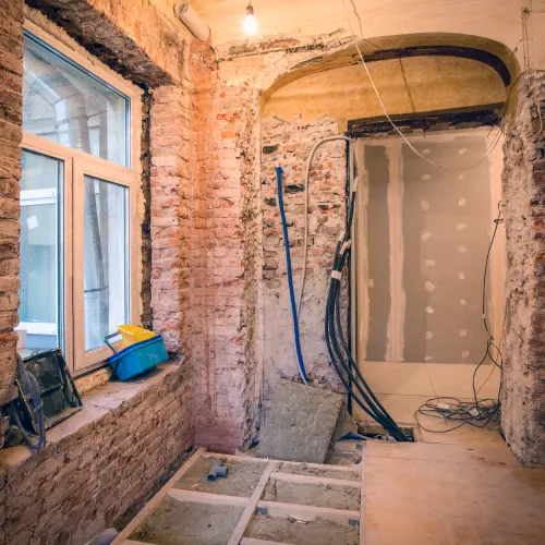 Interior de uma casa em remodelação, com parede em tijolo à vista